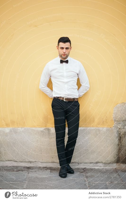Welldressed Businessman Leaning On Yellow Wall 20s Adults Architecture Attitude Back Behind Bow tie Businesspeople Businessperson Caucasian Self-confident