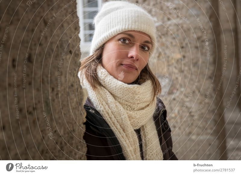 Portrait of woman with scarf and cap Relaxation Woman Adults Head 1 Human being Wall (barrier) Wall (building) Coat Scarf Cap Observe Looking Stand Friendliness