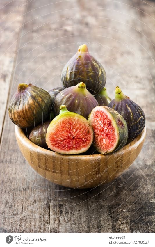 A few figs in a bowl on an old wooden background Fig Fruit Food Healthy Eating Food photograph Exotic Sweet Raw Red Fresh Tropical Slice Wood Group Half Natural