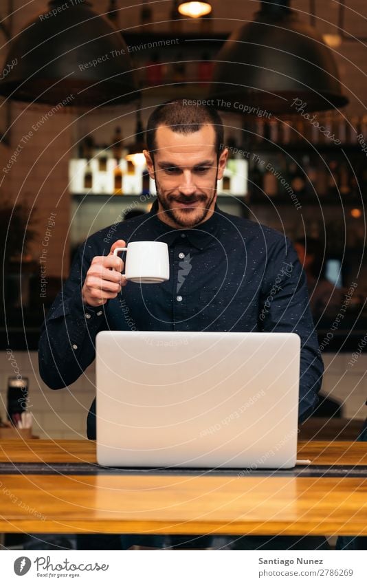 Businessman using his laptop in the Coffee Shop. Man Friendliness Portrait photograph Youth (Young adults) Human being Lifestyle Communication PDA Cellphone