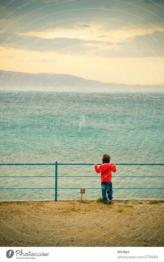 Child stands at a gelländer and looks out to the Croatian Mediterranean where the bora is just whipping across the water Far-off places Summer vacation Ocean