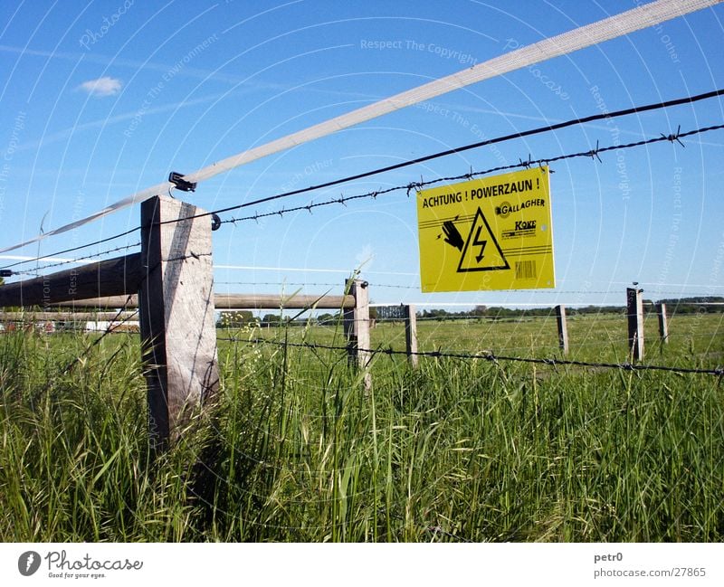 Watch your step! Power fence! Meadow Warning sign Electricity Green Clouds Vapor trail Barbed wire Fence. electric fence Signs and labeling Warning label