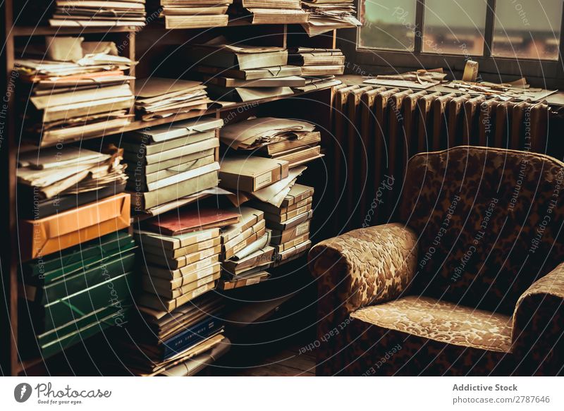 Old armchair near shelves with heap of papers Armchair shelf Heap Paper composition archive Vintage Document Room Accumulation Employees &amp; Colleagues type