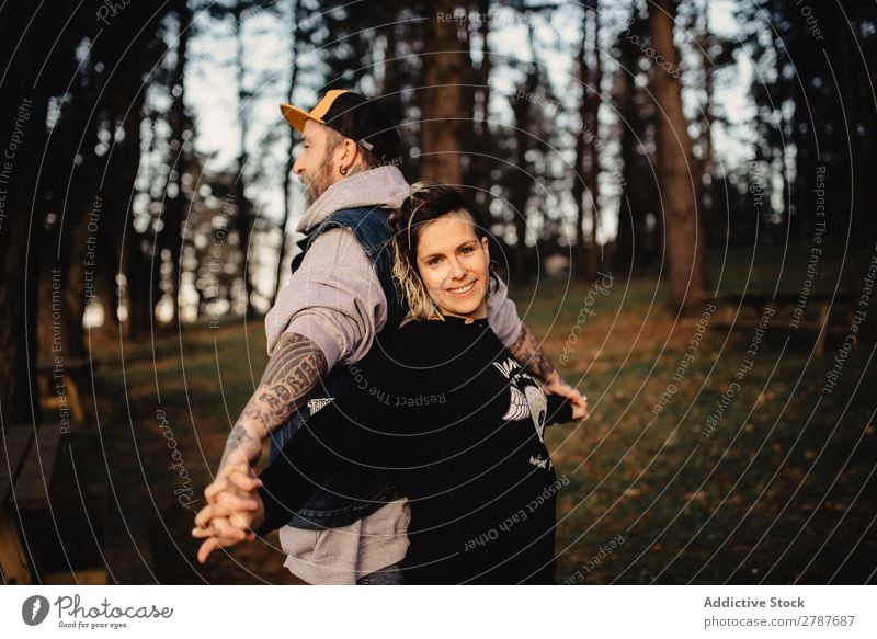 Young guy and happy lady standing back to back in forest Couple Tattoo Forest snapback Park Happy holding hands Lady Guy Youth (Young adults) Hipster Smiling