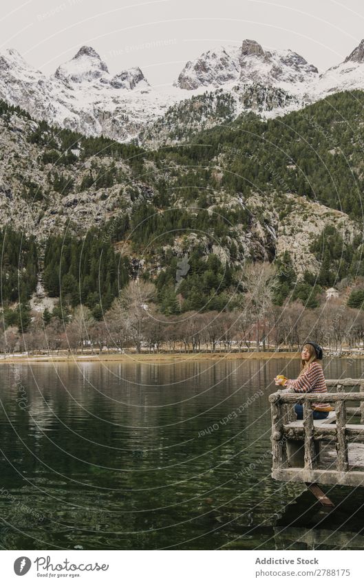 Woman on seat near wonderful lake between hills in snow and cloudy sky Lake Hill Seat Snow Pyrenees Sky Wonderful Water Surface Mountain Clouds Lady Height Tree