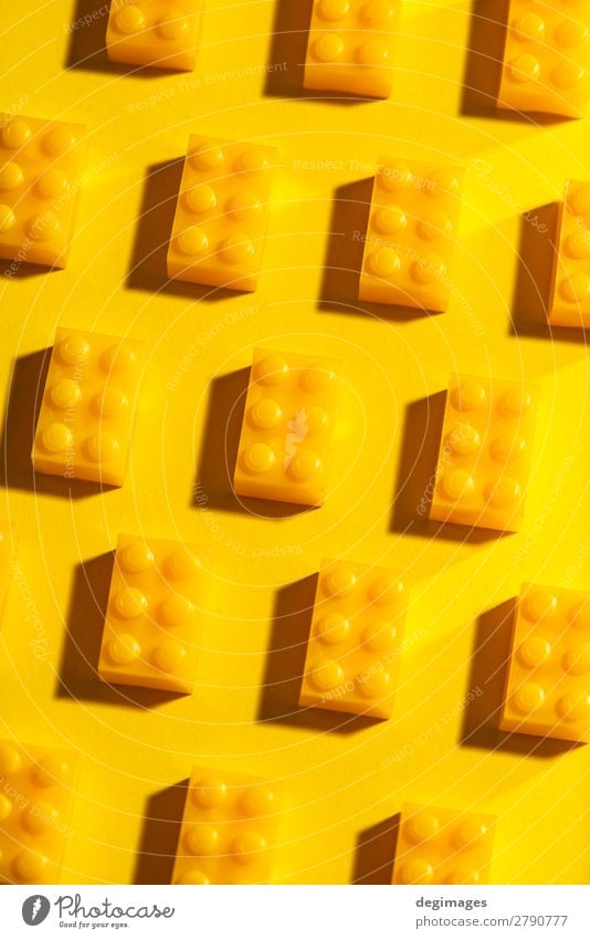 Yellow unicolour plastic geometric cubes. Construction toys Design Playing Child Infancy Toys Brick Plastic Build Colour blocks background rows Arranged LEGO
