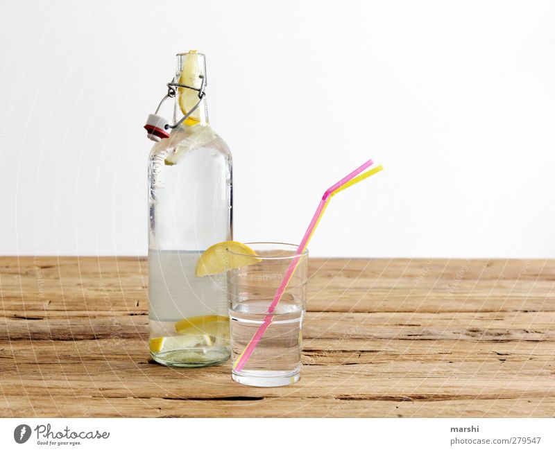 lemonade Beverage Drinking Cold drink Lemonade Bottle Glass Yellow Fruit Fruity Refreshment Blade of grass Thirst-quencher Water Wooden table Colour photo