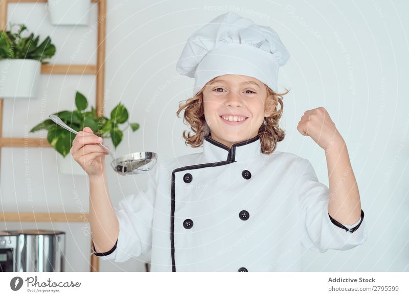 Boy in cook hat holding ladle near mouth in kitchen Cook Boy (child) Kitchen Ladle Mouth chef Child Pot tasting Food Hat Cooking Metal Modern Home Light