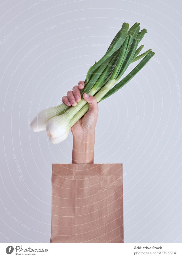 Person hand reached out from packet and holding leek Human being Hand Package Vegetable Food Bag Craft (trade) Paper Conceptual design Fresh Markets Healthy