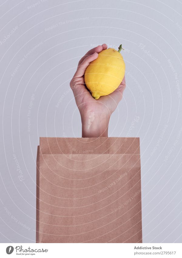 Person hand reached out from packet and holding lemon Human being Hand Carrot Package Vegetable Food Bag Craft (trade) Paper Conceptual design Fresh Markets
