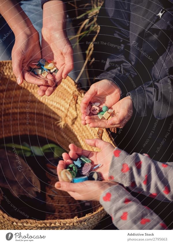 Person and children with heaps of garbage in hands near basket Trash container Heap Hand Basket Child Human being Accumulation Container Plastic cleaning up