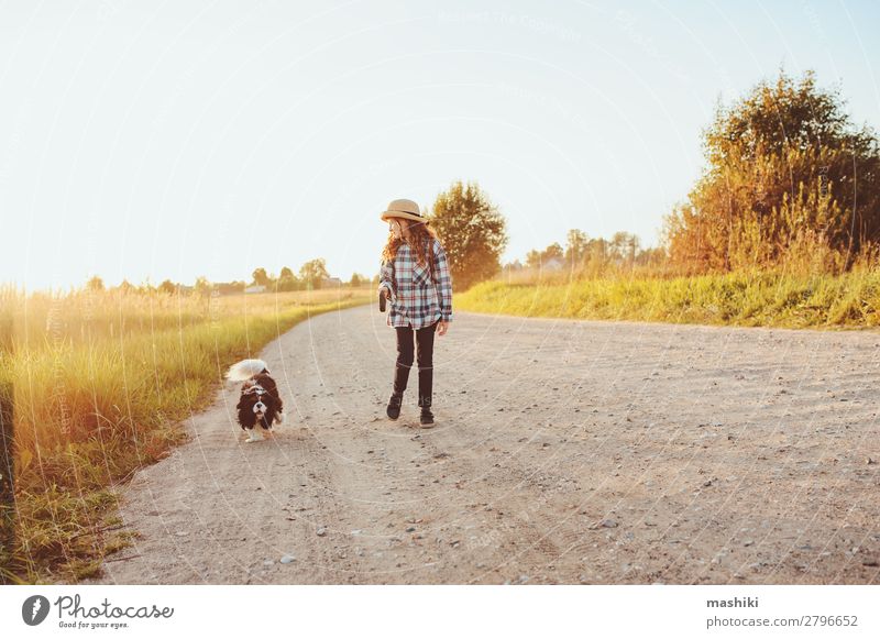 happy child girl walking country road with her dog Lifestyle Joy Leisure and hobbies Playing Vacation & Travel Trip Adventure Freedom Expedition Summer Hiking