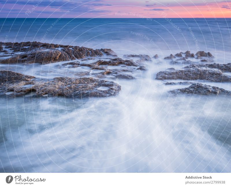 Sea waving near rough rocks during sunset Ocean Rock Waves Sunset Evening Sky Clouds Nature seascape Water Stone Rough rolling Splash Landscape Power Foam