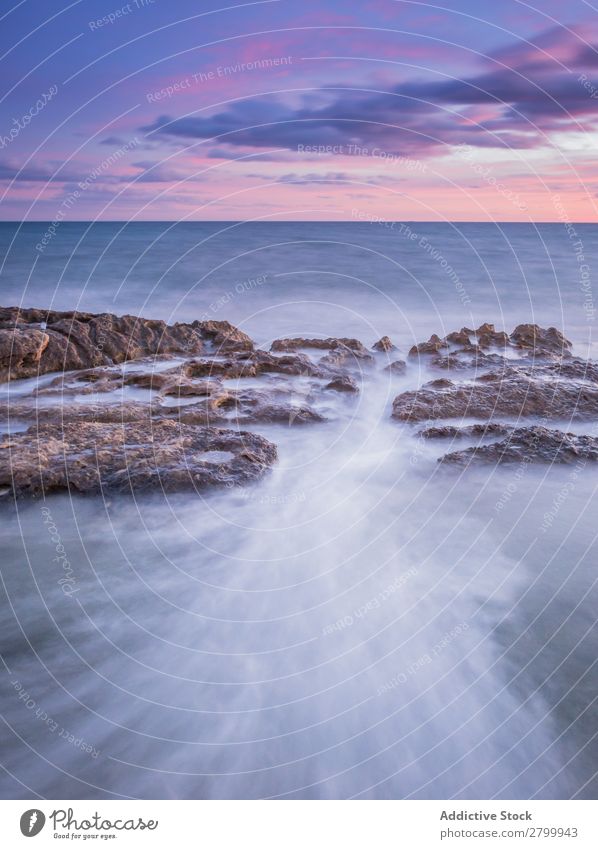 Sea waving near rough rocks during sunset Ocean Rock Waves Sunset Evening Sky Clouds Nature seascape Water Stone Rough rolling Splash Landscape Power Foam