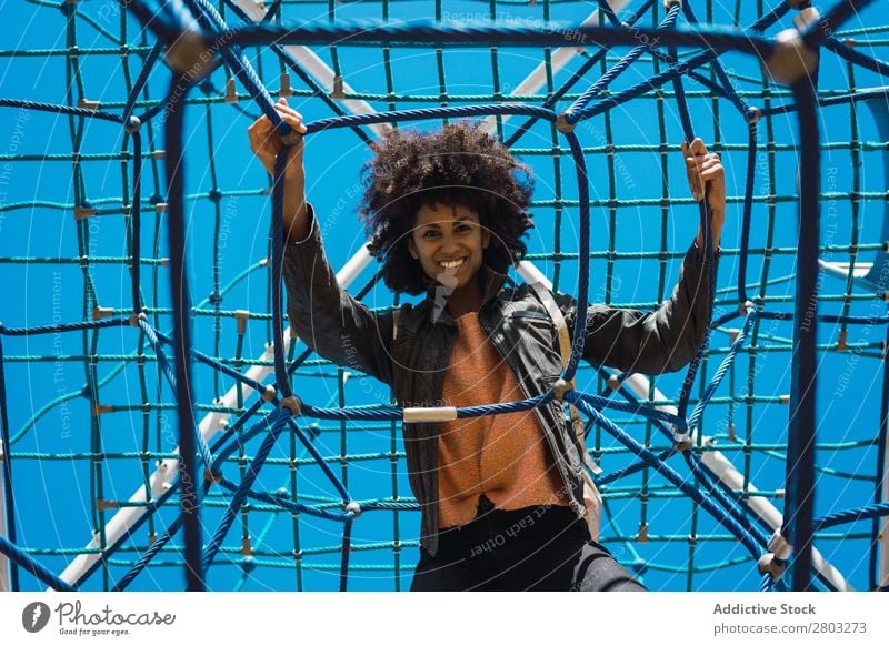 Woman with afro hair climbing by children's attractions. Action African Afro Black Cheerful Infancy Climbing Cute Equipment Family & Relations Joy Girl Happy