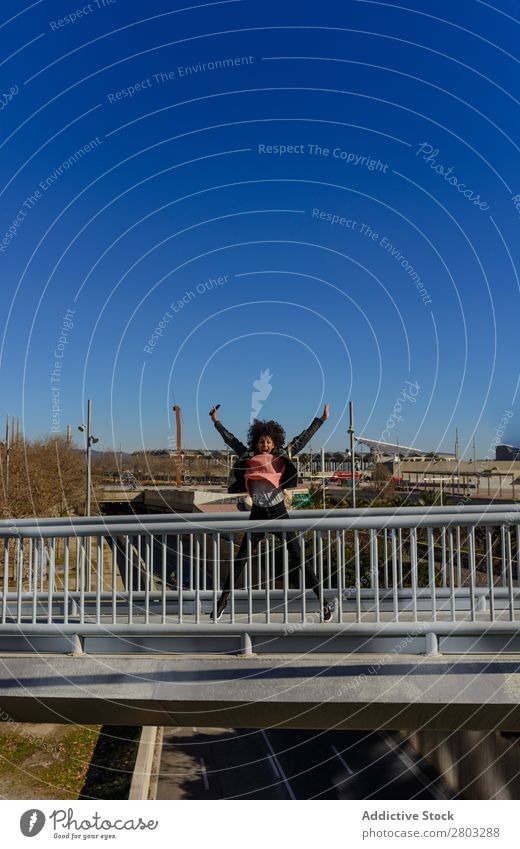 Woman with afro hair jumping for joy in the streets. African Afro American Background picture Beautiful Black Easygoing Cheerful Colour Energy enjoyment Fashion