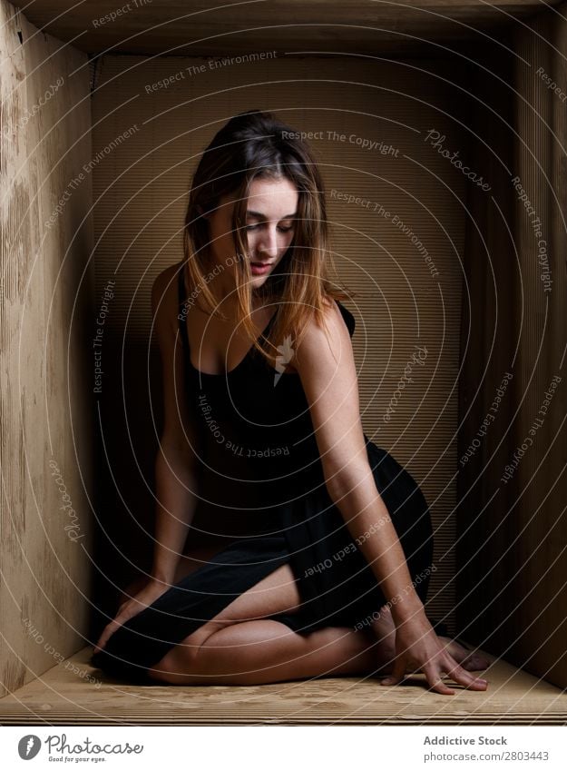 Provocative woman sitting in carton box Woman Alluring Dress Box caption Conceptual design Posture Delightful To enjoy Attractive Model constrained Contemporary