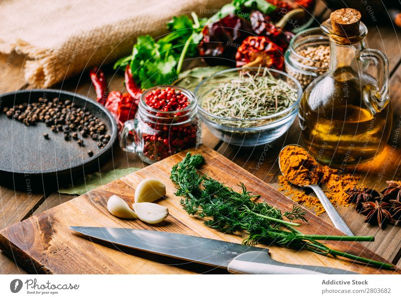 Spices and oil near knife Herbs and spices Oil Knives Table assortment Cooking Ingredients Set Fresh Dill Parsley Garlic anise turmeric Cardamom Coriander Chili