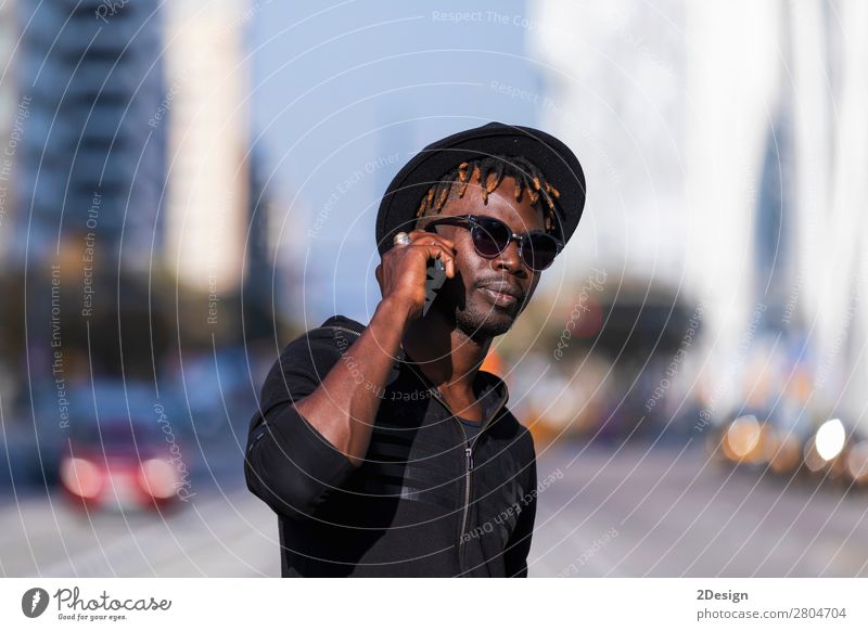 Front view of black man with sunglasses and hat standing Lifestyle Style Happy Leisure and hobbies To talk Telephone PDA Technology Human being Masculine