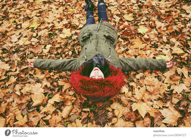 Young brunette woman lying down over autumn leaves Lifestyle Style Face Healthy Wellness Well-being Relaxation Calm Leisure and hobbies Human being Feminine