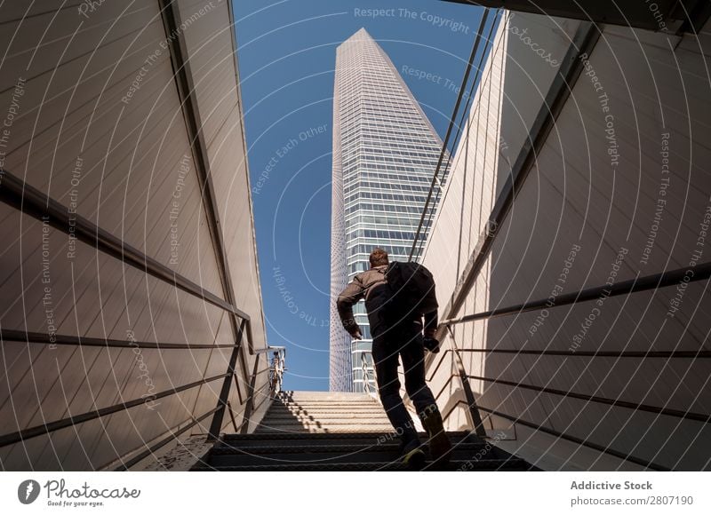 Man climbing the stairs to the skyscraper - 4 Stairs Office City High-rise Human being Exterior Modern Business center up Madrid Success Town Skyline Spain