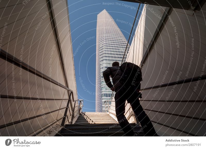 Man climbing the stairs to the skyscraper - 2 Stairs Office City High-rise Human being Exterior Modern Business center up Madrid Success Town Skyline Spain