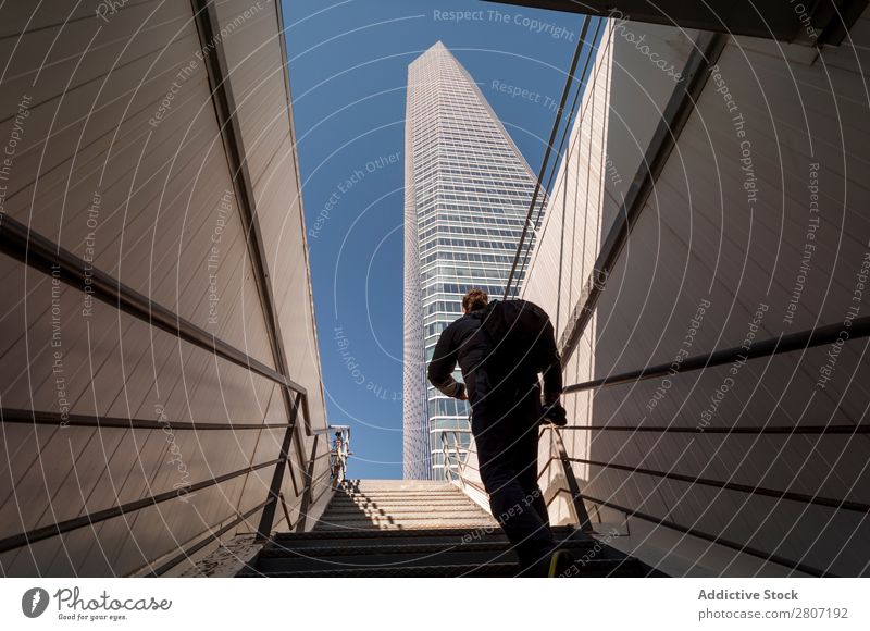 Man climbing the stairs to the skyscraper - 3 Stairs Office City High-rise Human being Exterior Modern Business center up Madrid Success Town Skyline Spain