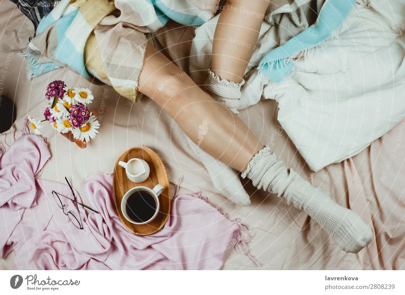 White tanned woman in white socks sitting in her bed Cozy Winter Autumn flat lay hygge Adults Loneliness Beautiful Bed Bedclothes Blanket Duvet care Coffee
