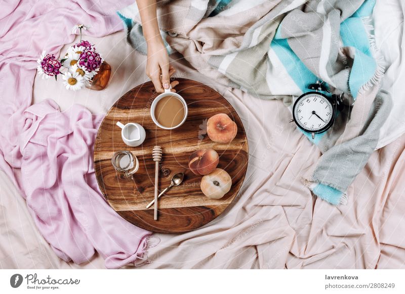 Cozy flatlay of wooden tray with cup of coffee, peaches, creamer Alarm clock Morning Cup Mug flat lay Bedroom Breakfast Espresso Syrup Spoon Fruit Peach Bouquet