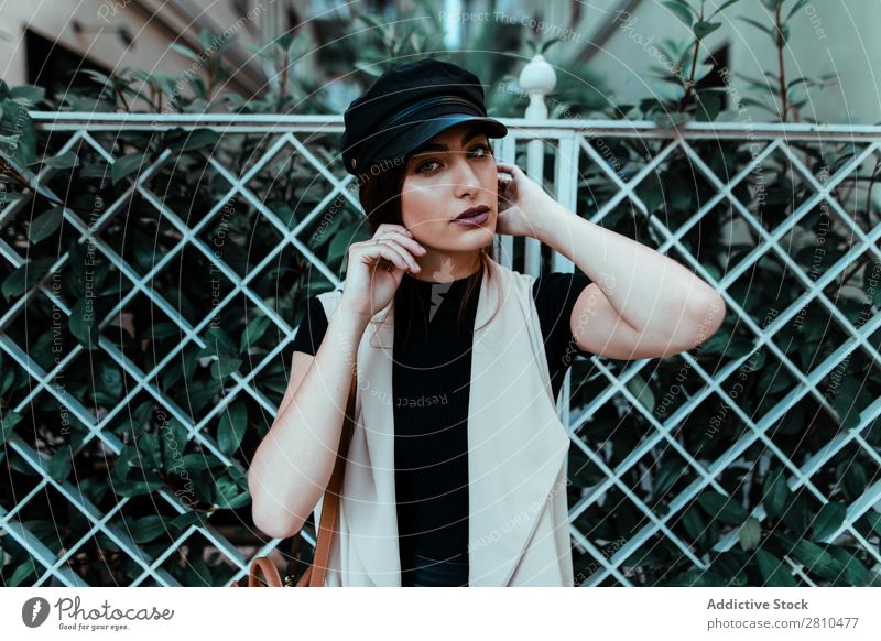 Pretty stylish woman putting on cap Woman Style Youth (Young adults) Street Beautiful Cap Fence City Fashion pretty Attractive Model Human being