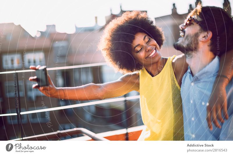 Young couple multicultural taking selfie laughing in love on the rooftop Affectionate African Beautiful boyfriend Caucasian Solar cell Couple dating