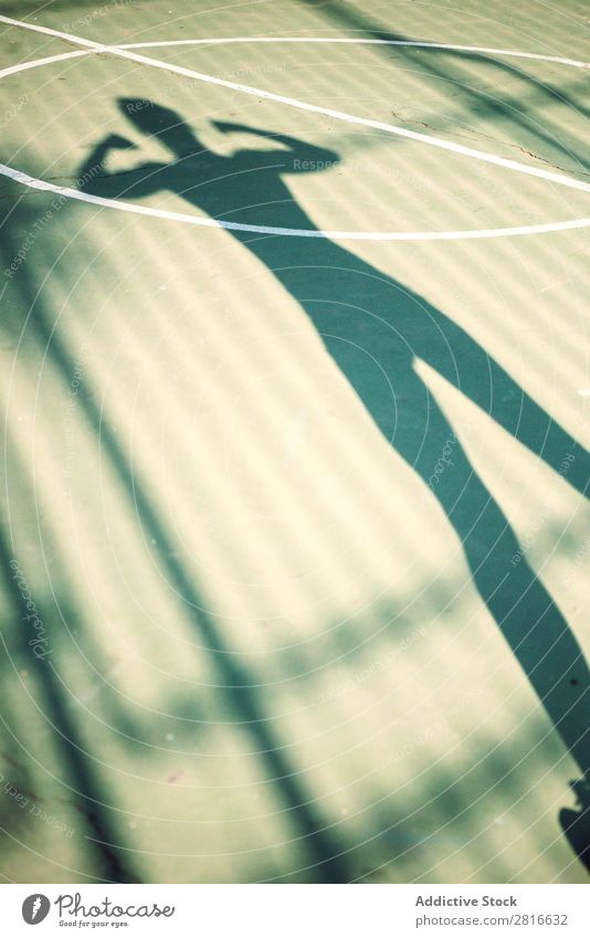 Shadow of running woman on a basketball court Fitness Sports Running Stretching Runner Jogger Exterior shot Girl Warmth Lanes & trails Legs Human being Back