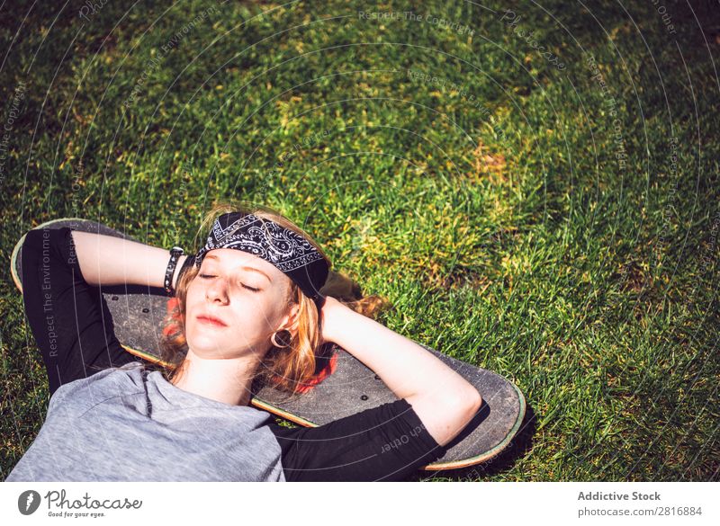 Young woman resting in the grass after practicing skateboard chill Girl Hipster Skateboard Youth (Young adults) Park Light Rest Lie (Untruth) Woman Relaxation