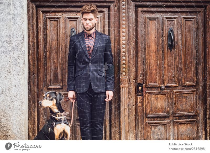Handsome elegant young fashion man in trendy costume suit with a dog, old wooden door background Suit Man Gentleman Fashion fashionable Clothing Style Model