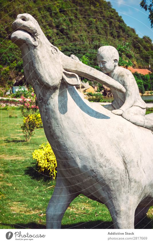 Statue of young boy with a buffalo Vietnam Buffalo Exterior shot Thailand Pet Meadow Park Mammal Boy (child) Human being Smiling Asia Love Friendship Hearty