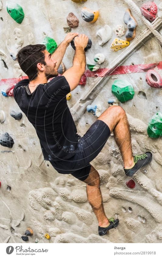 Man practicing rock climbing on artificial wall indoors. Lifestyle Joy Leisure and hobbies Sports Climbing Mountaineering Masculine Adults Hand Feet 1