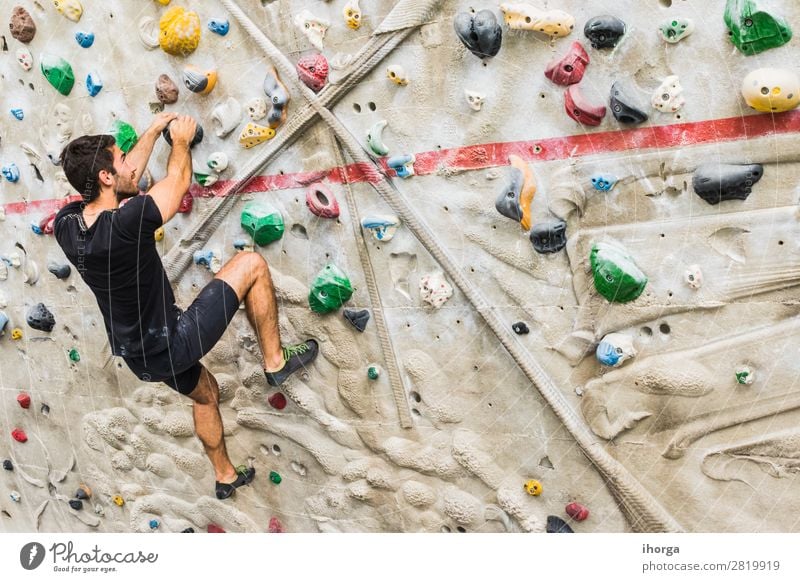 Man practicing rock climbing on artificial wall indoors. Lifestyle Joy Leisure and hobbies Sports Climbing Mountaineering Human being Adults 1 18 - 30 years