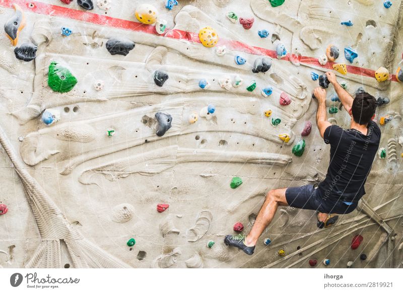 Man practicing rock climbing on artificial wall indoors. Lifestyle Joy Leisure and hobbies Sports Climbing Mountaineering Adults 1 Human being 18 - 30 years