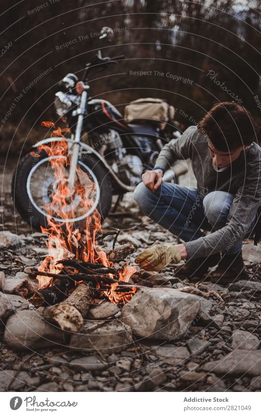 Traveler keeping camp fire Man traveler Fireplace Motorcycle Loneliness Expedition Flame Firewood Wanderlust Action Adventure Traveling Tourism Hiking Transport