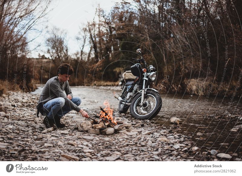 Traveler keeping camp fire Man traveler Fireplace Motorcycle Loneliness Expedition Flame Firewood Wanderlust Action Adventure Traveling Tourism Hiking Transport