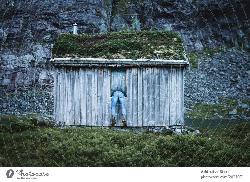 Anonymous man in window of old cabin Man Hut Mountain Remote tranquil Window terrain bending House (Residential Structure) but Nature Landscape Peaceful