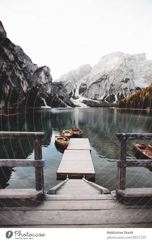 Pier on mountain lake Lake Mountain Jetty Watercraft Vantage point Landscape Nature Sky Beautiful Tourism Vacation & Travel Peak scenery Reflection Sunbeam Day