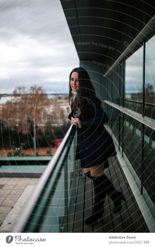 Cheerful woman standing at handrail Woman pretty Youth (Young adults) Beautiful Smiling Stand Balcony Building Modern Contemporary Brunette Attractive