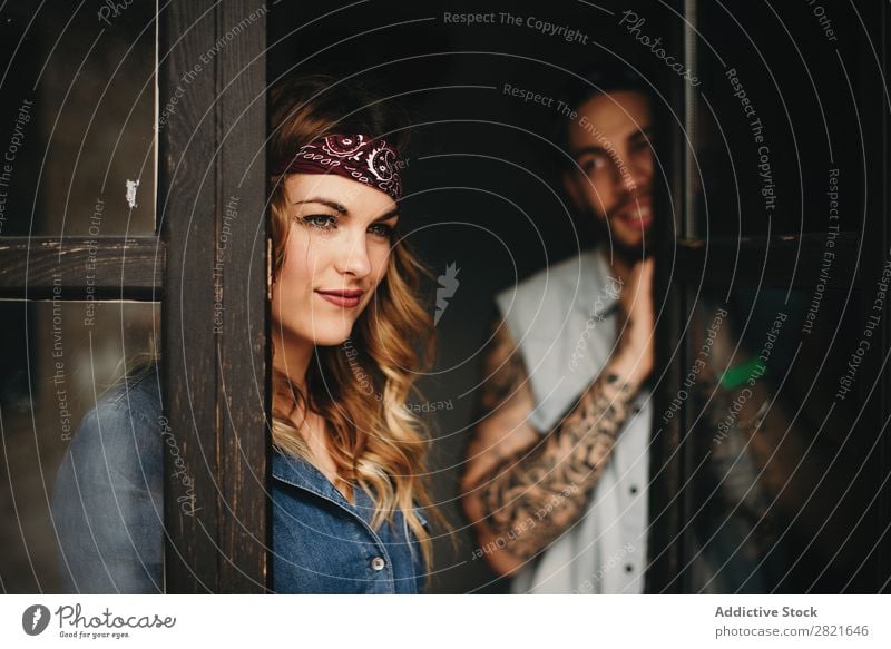 Smiling woman with band on head against of her boyfriend looking at her Couple Tattoo Portrait photograph Window Looking away pretty Beautiful Attractive