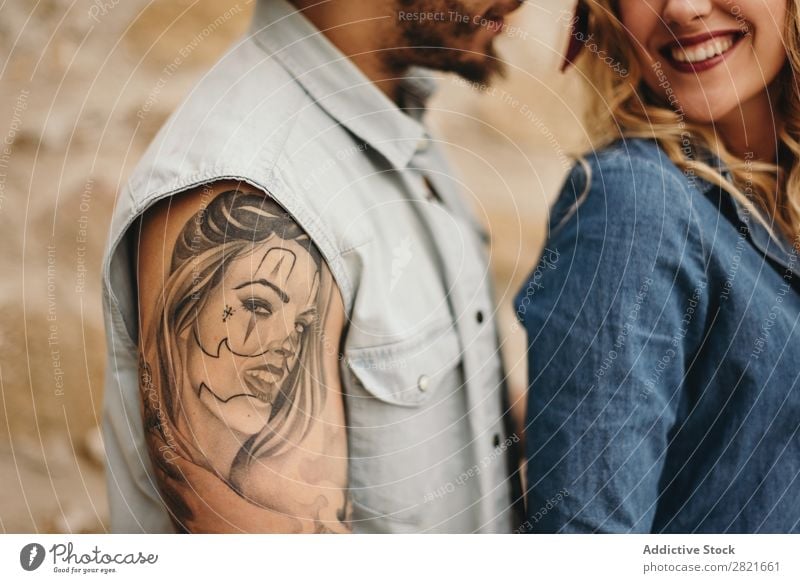Couple in close up. Man with tattoo of his girlfriend's face Smiling Tattoo Portrait photograph Face Girl Unrecognizable Close-up body part Arm Shoulder