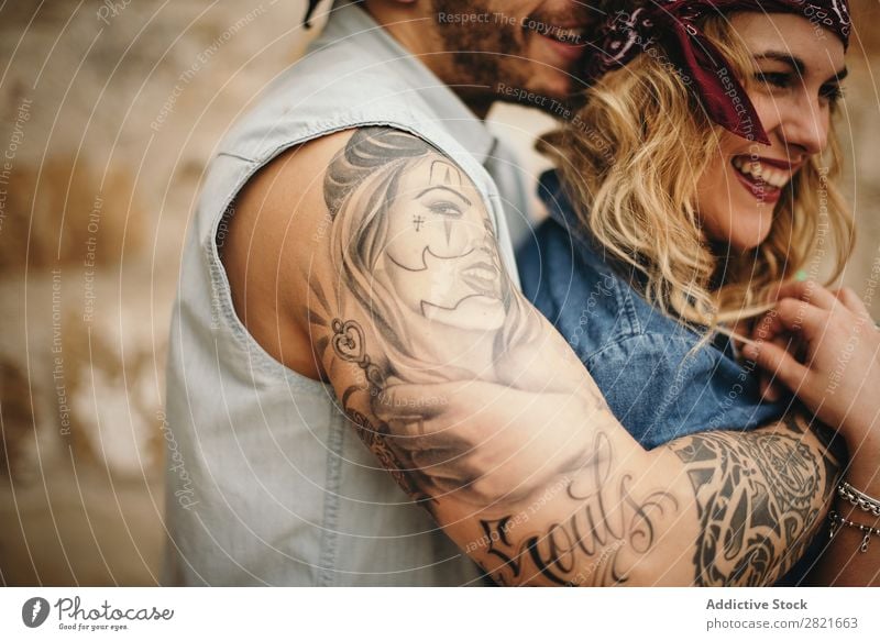 Boyfriend embracing his smiling girlfriend Couple Smiling Tattoo Arm Embrace Profile toothy smile Happy Beautiful Face Girl Close-up body part Shoulder