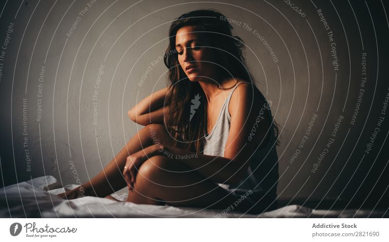 Beautiful young woman in grey sitting on bed Woman Bed sittng looking down Gray Wall (building) Background picture Intimate Intimacy Sadness Loneliness Posture