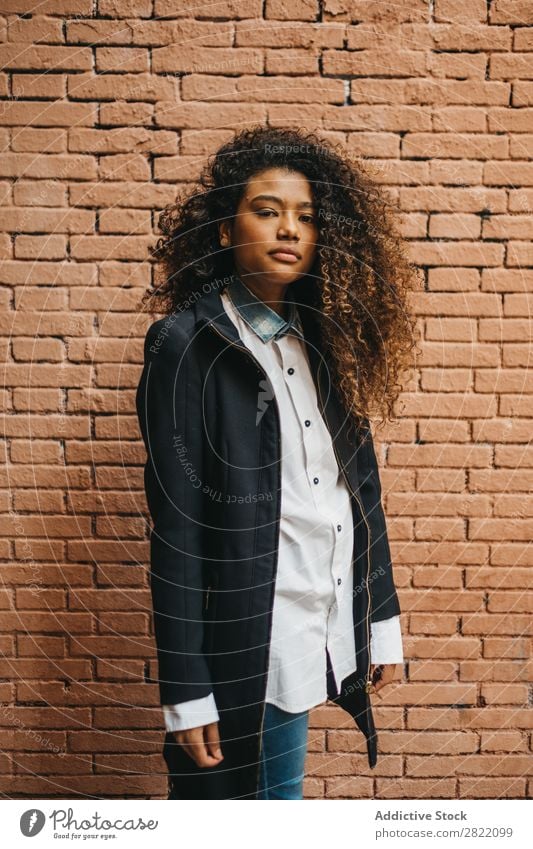 Stylish woman at brick wall Woman pretty Beautiful Ethnic Black Curly African Youth (Young adults) Stand Wall (building) Brick Street Brunette Attractive