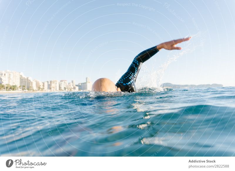 Man in wetsuit swimming in ocean Wetsuit Swimming Ocean Sports Athlete Aquatics Movement Action Water Vacation & Travel Rowing Leisure and hobbies Sunlight