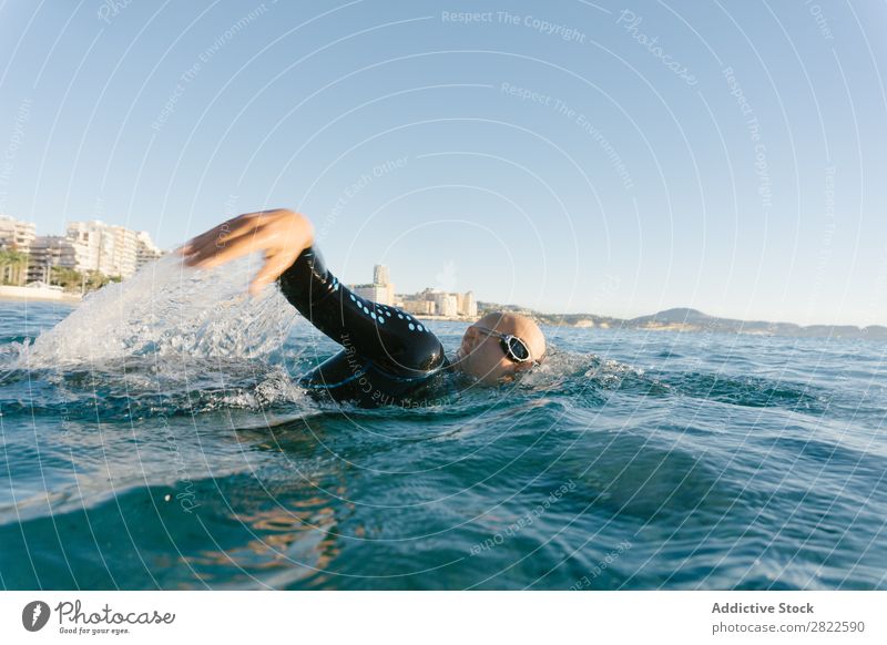 Man in wetsuit swimming in ocean Wetsuit Swimming Ocean Sports Athlete Aquatics Movement Action Water Vacation & Travel Rowing Leisure and hobbies Sunlight